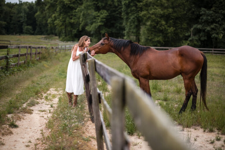 selling horse property, Denise with a horse by the fence